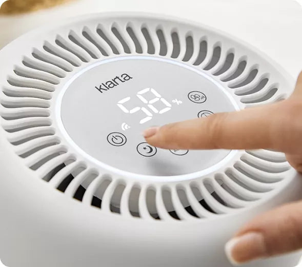 Finger setting the target humidity on the Klarta Humea control panel, display reading 58%