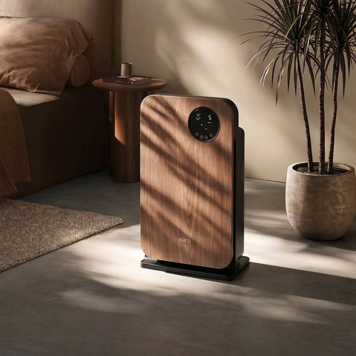 Klarta Forste smart air purifier in Wood Black standing in a sunlit bedroom beside the bed