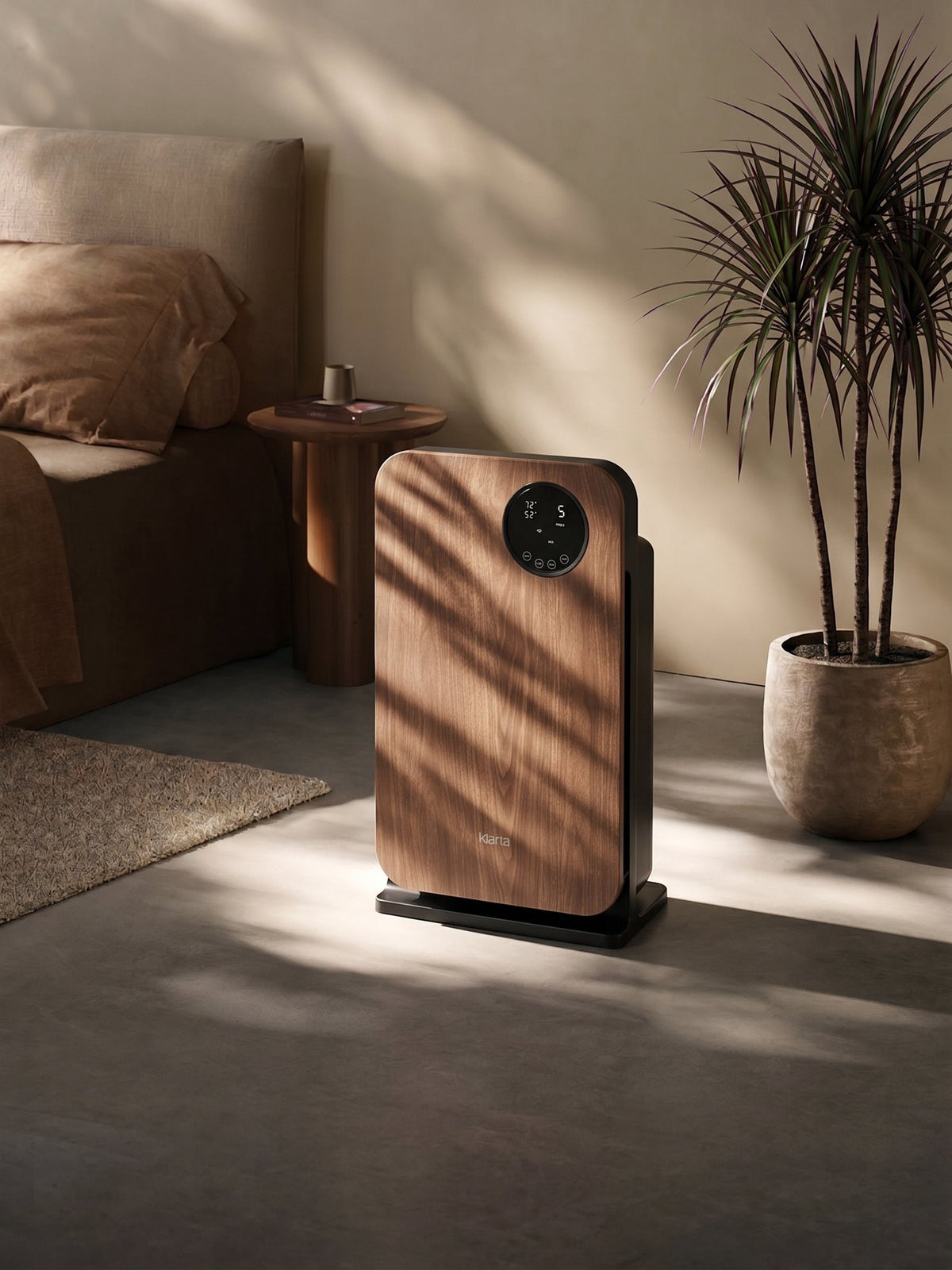 Klarta Forste smart air purifier in Wood Black standing in a sunlit bedroom beside the bed