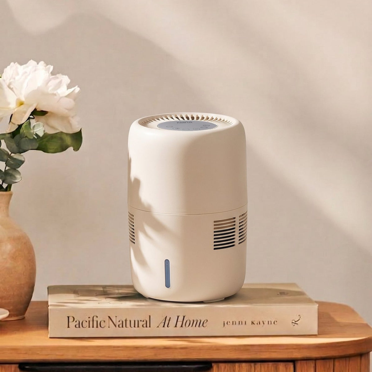 Klarta Humea evaporative humidifier in Beige on a wooden sideboard next to white flowers