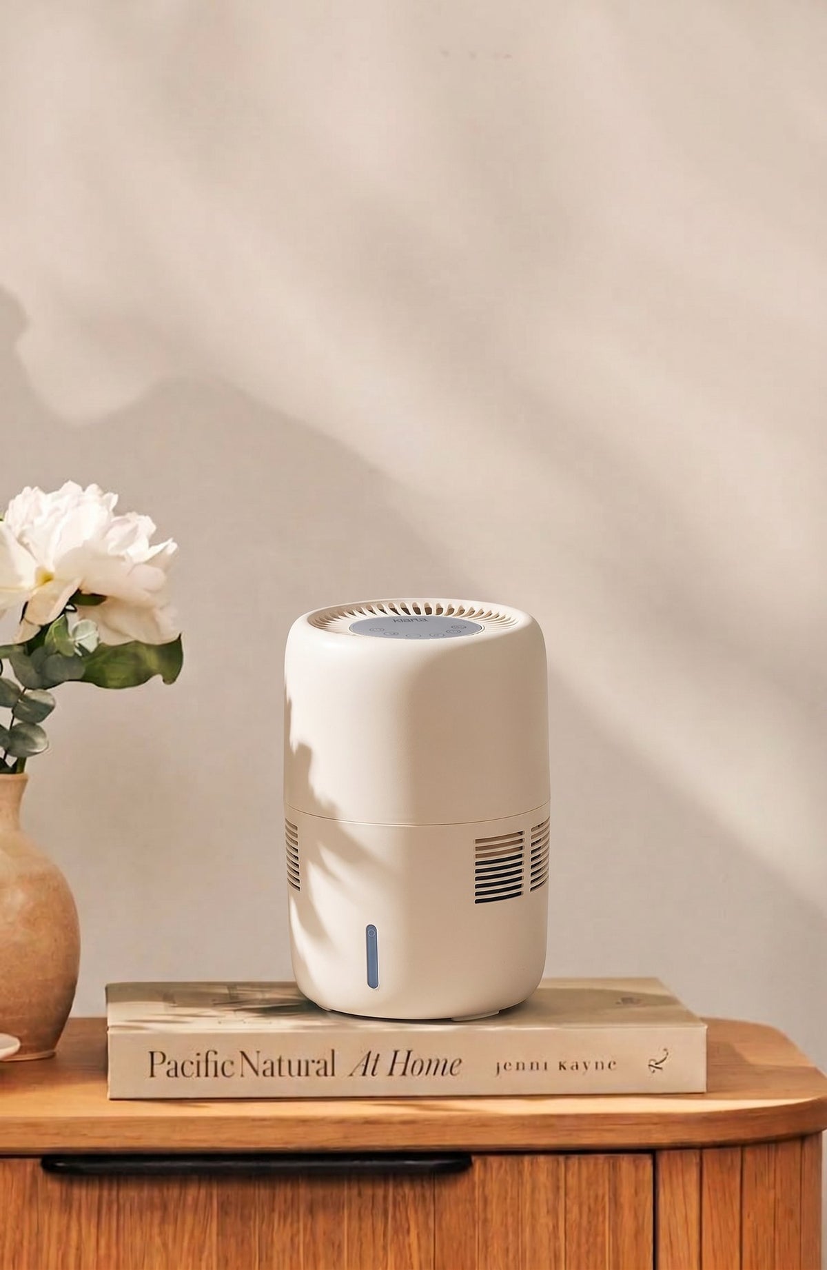 Klarta Humea evaporative humidifier in Beige on a wooden sideboard next to white flowers